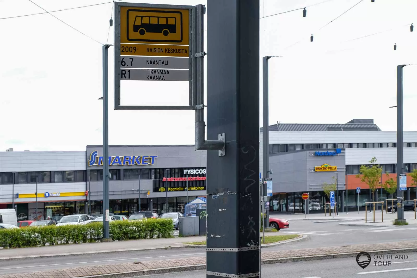Mit dem Bus von Kustavi nach Naantali - Umsteigen in Raisio In Raisio musst du umsteigen. Die Bushaltestelle nach Naantali ist etwas versteckt, nur an einem Lampenmast hängt ein Schild