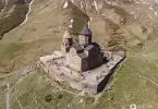 Gergeti Dreifaltigkeitskirche mit Glockenturm aus der Vogelperspektive